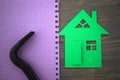 Green cutout of model house with hand tool on a notepad Royalty Free Stock Photo