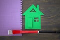 Green cutout of model house with hand tool on a notepad Royalty Free Stock Photo