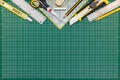 Green cutting mat on desk with school or office supplies Royalty Free Stock Photo