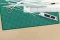 Green cutting mat with scissors, cutter and metal ruler on desk Royalty Free Stock Photo