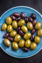 Green and dark olives on a blue greek plate.