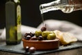 Green and dark olives on a brown greek plate.