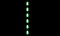 Green dashes aligned following a vertical line on a black wall