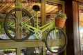 Green decorative bicycle hanging on a glass window in the street Royalty Free Stock Photo