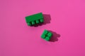 Green details cubes of children`s constructor on a pink background