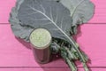 Green detox juice from cabbage leaves on pink background