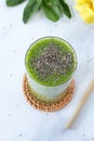 Green detox smoothie glass with pineapple, spinach, and chia seeds with eco-friendly bamboo straw on white Royalty Free Stock Photo
