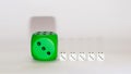 green dice next to white little white dices on a white background with shadows.still life visual design Royalty Free Stock Photo