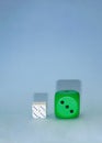 green dice next to white little white dices on a blue background with shadows.still life visual design Royalty Free Stock Photo