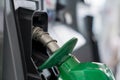 Green diesel fuel nozzle in resting position at gas station pump Royalty Free Stock Photo