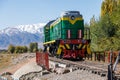 green diesel locomotive crossing small bridge at summer day in Balykchy, Kyrgyzstan Royalty Free Stock Photo