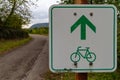 Green directional sign for bikers to ride straight on (blurry ba Royalty Free Stock Photo