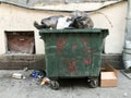 Green dirty trash dumpster. Overcrowded city trash can Royalty Free Stock Photo