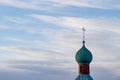 Green dome of a rural church in Russia with a cross on the background of the spring sky. Cross on the dome of the Orthodox Church Royalty Free Stock Photo