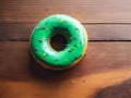 Green donut with multicolor sprinkles on a wooden background Royalty Free Stock Photo