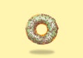 Green donut on on pastel yellow background