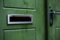 Green door with a hole for mail empty mail box Royalty Free Stock Photo