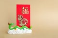 The green dragon statue and red envelope on light brown background. 2024 New Year.translate Chinese alphabets Fu on red envelope Royalty Free Stock Photo