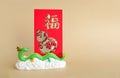 The green dragon statue and red envelope on light brown background. 2024 New Year. Royalty Free Stock Photo