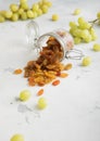 Green dried sweet raisins in glass jar on light background.Macro