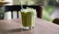 A green drink in a glass with a green straw