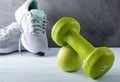 1 green dumbbell, Apple, gray sneakers on a gray