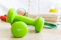 Green dumbbells, water bottle, apple, jump rope and a towel. Set for sports.