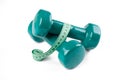 Green dumbell with measuring tape Royalty Free Stock Photo