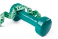 Green dumbell with measuring tape Royalty Free Stock Photo
