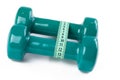 Green dumbell with measuring tape Royalty Free Stock Photo