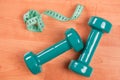 Green dumbell with measuring tape