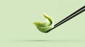 Green dumpling held by chopsticks against a soft pastel background, showcasing Royalty Free Stock Photo