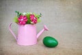 Green Easter egg and fabric flowers arranged in watering bucket