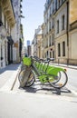 Green ecological electric bicycles with baskets for public rent await tourists cyclists on the streets of Paris Royalty Free Stock Photo