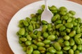 Green Edamame soy beans on white plate with fork Royalty Free Stock Photo