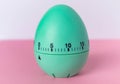 Green egg timer on pink background. Happy Easter in the kitchen. Home related, home staying. Free copy space. Flat lay, top view Royalty Free Stock Photo