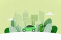 Green electric car charging at the charger station on the street with green city skyline in the background. Sustainable energy and Royalty Free Stock Photo