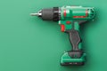 Green electric screwdriver drill on green background with space for text