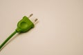 green electric wire and plug on a light peach background