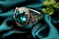 Green Emerald Fashion Engagement Diamond Ring on Green Satin Background.