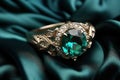 Green Emerald Fashion Engagement Diamond Ring on Green Satin Background.