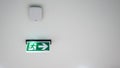 Green emergency exit sign. Direction to the escape way on white Royalty Free Stock Photo