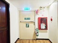 Green emergency Exit sign and fire extinguisher at building. Fire exit door and fire extinguish equipment.