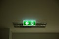 Green emergency exit sign showing the way to escape.