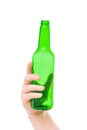 green empty beer bottle in female hand on a white Royalty Free Stock Photo