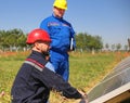 Green energy, two electricians control solar panels Royalty Free Stock Photo