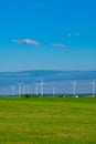 Green energy.Wind generator and home in green field.Windmills on blue sky background.renewable energy. Environmentally