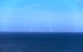 Green energy wind turbine generator in the middle of an ocean, shades of blue Royalty Free Stock Photo