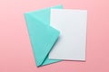 Green envelope and blank letter on pink background. Template with place for text on postcard. mock-up Royalty Free Stock Photo