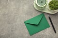 Green envelope, pen and candle on grey background Royalty Free Stock Photo